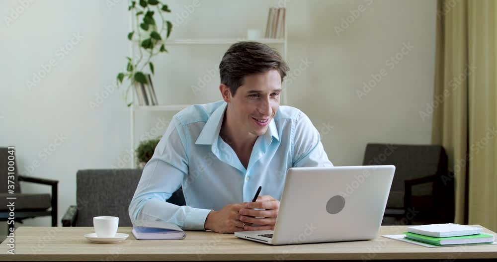 Smiling classic man sits at table at home in office, uses laptop web camera to communicate with family friends, actively speaks on video conference network gestures with hands, answers Internet call Smiling classic man sits at table at home in office, uses laptop web camera to communicate with family friends, actively speaks on video conference network gestures with hands, answers Internet call