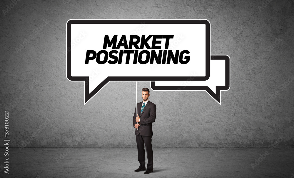 Young business person in casual holding road sign with MARKET POSITIONING inscription, new business idea concept Young business person in casual holding road sign with MARKET POSITIONING inscription, new business idea concept