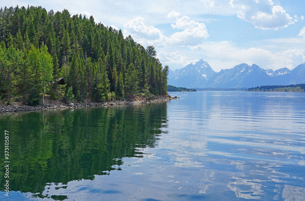 View of mountain peaks reflecting in water in summer in Grand Teton National Park in Wyoming, United States