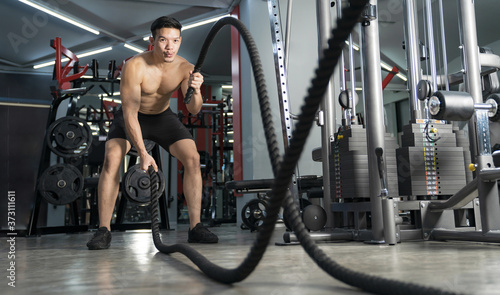 Man working out with battle ropes at gym, Functional training, Sport fitness training