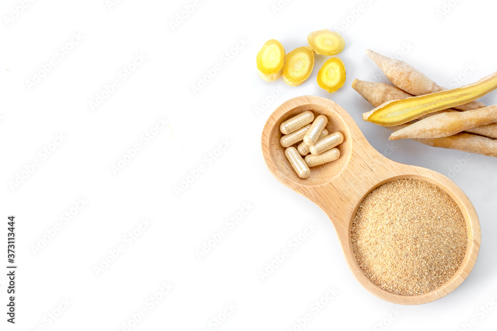 Fingerroot ( Chinese Ginger, Galingale, Kaempfer, Boesenbergia rotunda, Krachai ) with power and capsules in wooden bowl isolated on white. Fingerroot ( Chinese Ginger, Galingale, Kaempfer, Boesenbergia rotunda, Krachai ) with power and capsules in wooden bowl isolated on white.