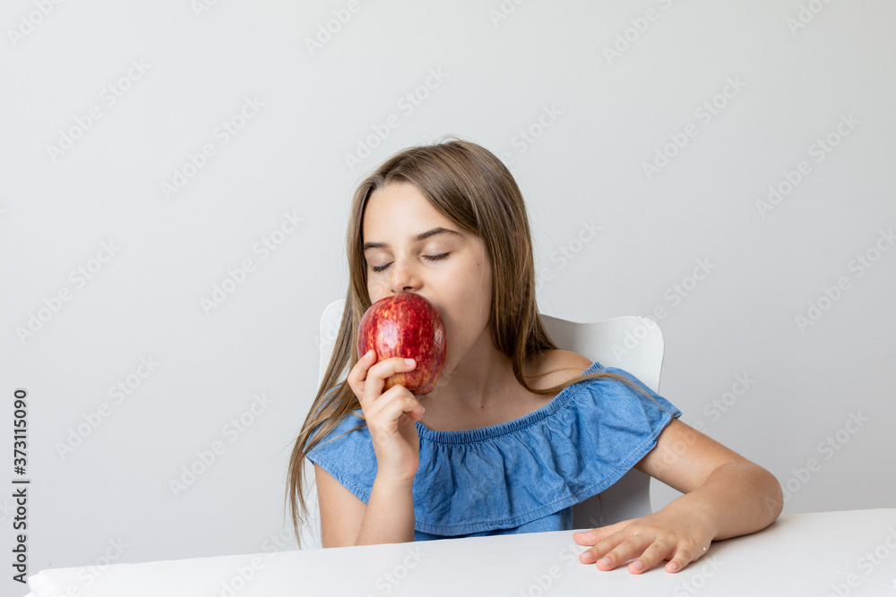 Criança feliz se deliciando com maça saborosa e fazendo caretas Criança feliz se deliciando com maça saborosa e fazendo caretas