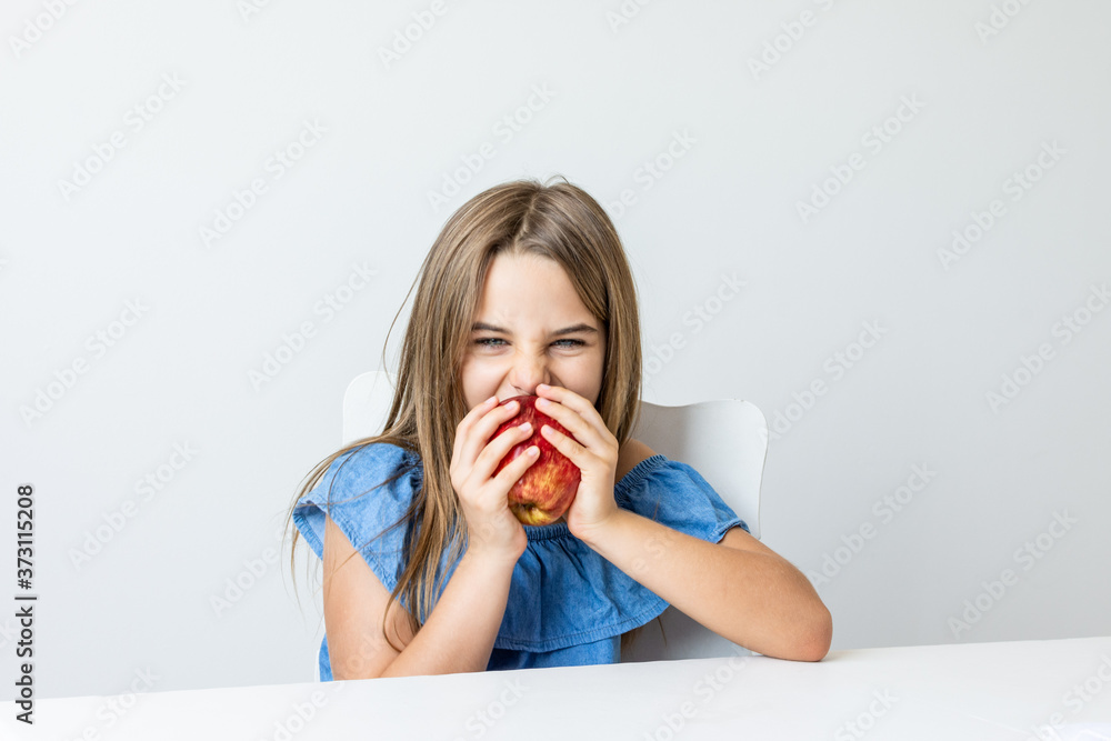 Criança feliz se deliciando com maça saborosa e fazendo caretas Criança feliz se deliciando com maça saborosa e fazendo caretas