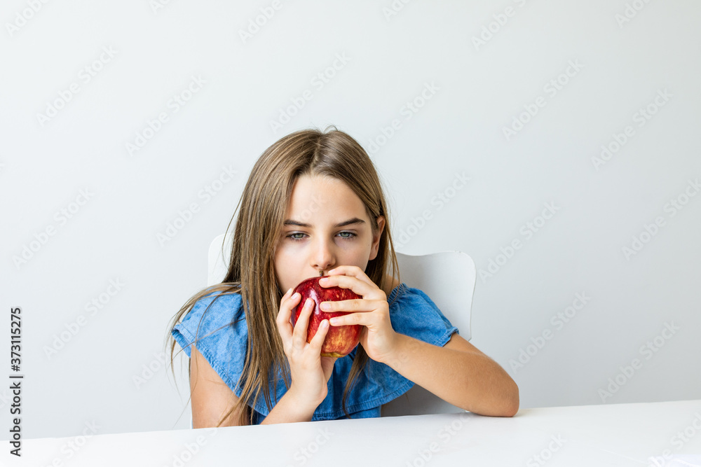 Criança feliz se deliciando com maça saborosa e fazendo caretas Criança feliz se deliciando com maça saborosa e fazendo caretas