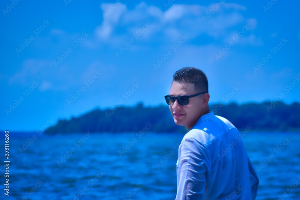 portrait of a young man inside the beach wearing sunglasses and a t-shirt portrait of a young man inside the beach wearing sunglasses and a t-shirt