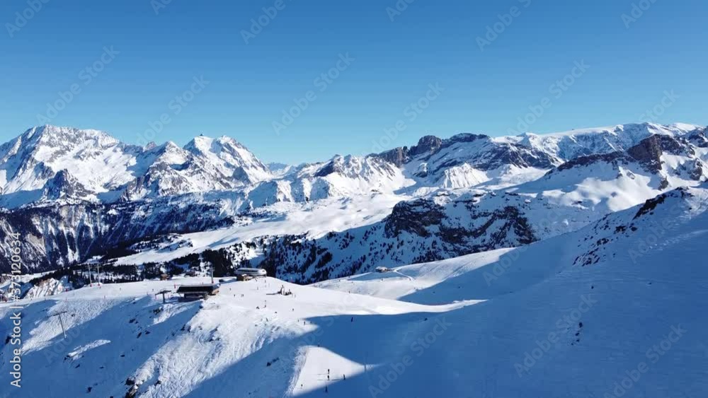 Aerial view of the Alps mountains in France. Mountain tops covered in snow. Alpine ski facilities from above. Aerial view of the Alps mountains in France. Mountain tops covered in snow. Alpine ski facilities from above.