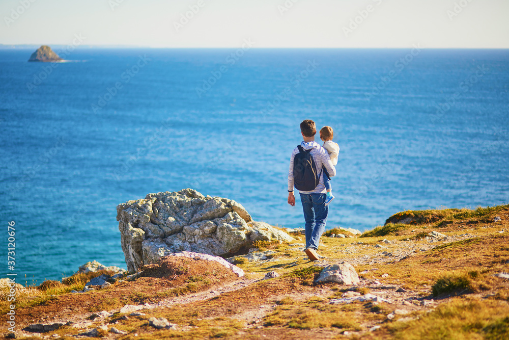 Father and daughter enjoying scenic view of Crozon peninsula, Brittany, France