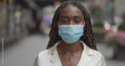 Canvas Print Young black woman in city face portrait wearing a mask serious