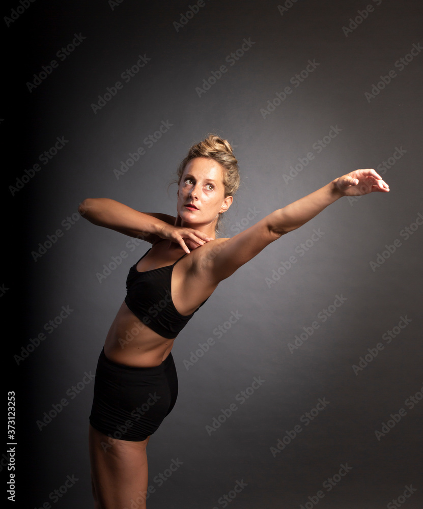 Ballerina dance in studio, black background