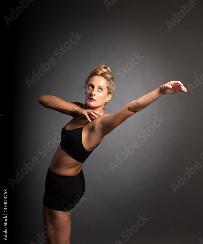 Ballerina dance in studio, black background