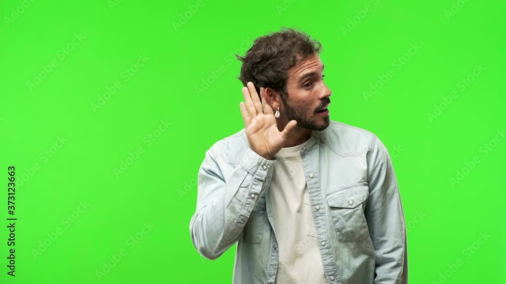young man on chroma green screen try to listening a gossip young man on chroma green screen try to listening a gossip