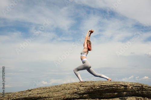 Girl does yoga against the sky