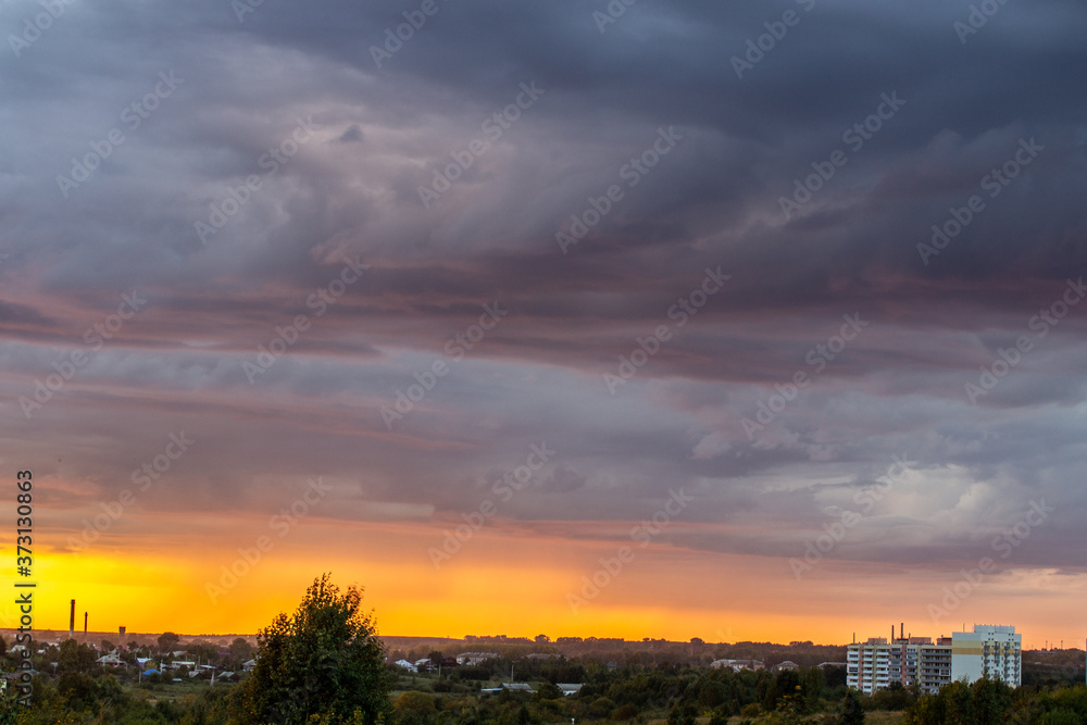 Very beautiful sunset in the city or village. Pink-orange sky with clouds.