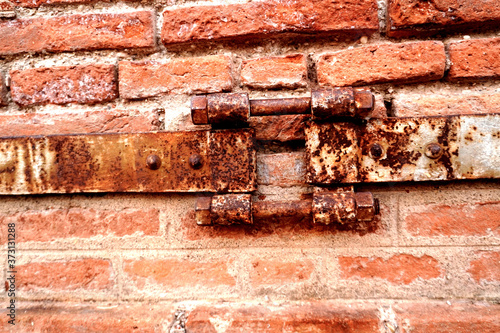 Fotografering old iron tying crumbling brick structure
