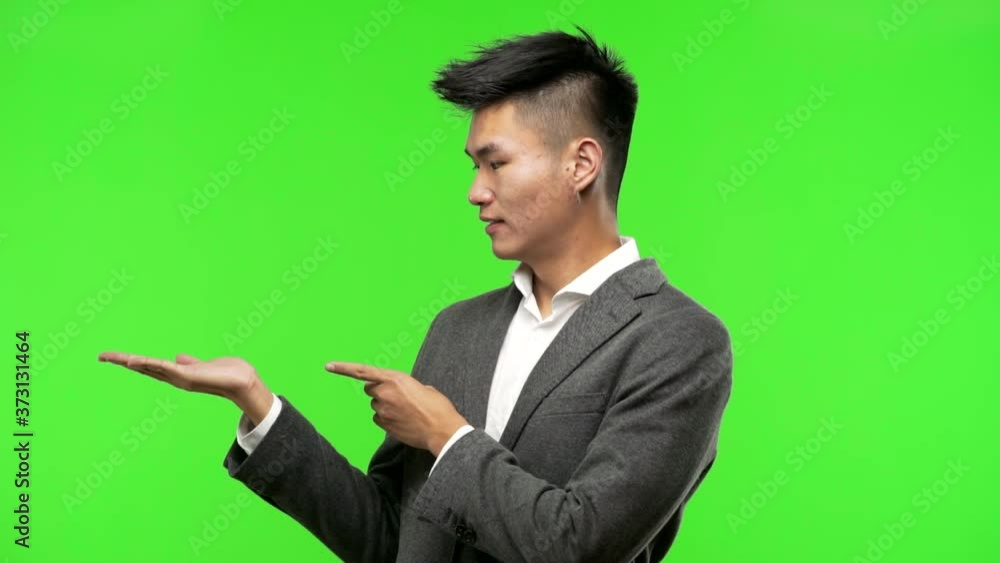 Young chinese business man holding something with hand Young chinese business man holding something with hand