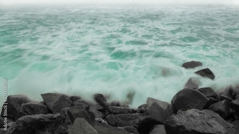 Fototapeta premium A Colorful Ocean Sunset Sky as a Gentle Wave Rolls to Shore