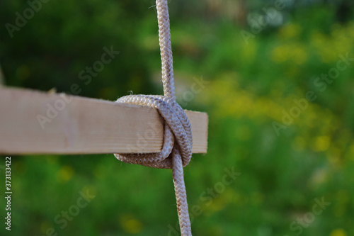 Photography Selective focus shot of clove hitch knot on blur green background