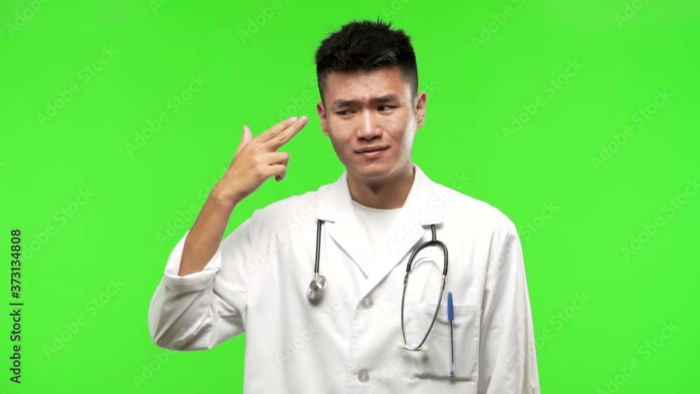 Young chinese doctor man making a suicide gesture Young chinese doctor man making a suicide gesture