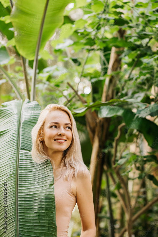 Woman in swimsuit on tropical plants background Woman in swimsuit on tropical plants background