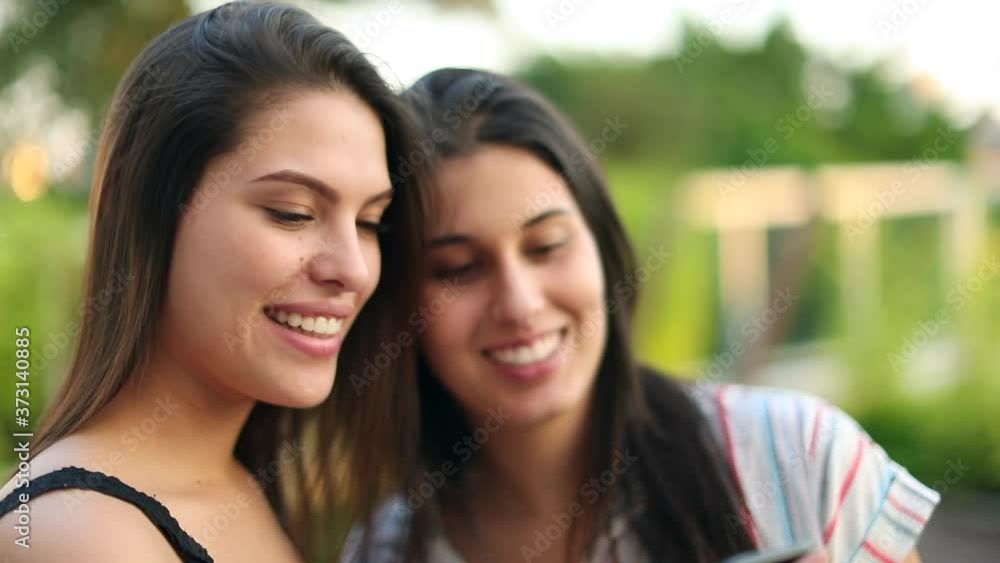 Millennial women take selfie posing outdoors and checking smartphone photo Millennial women take selfie posing outdoors and checking smartphone photo