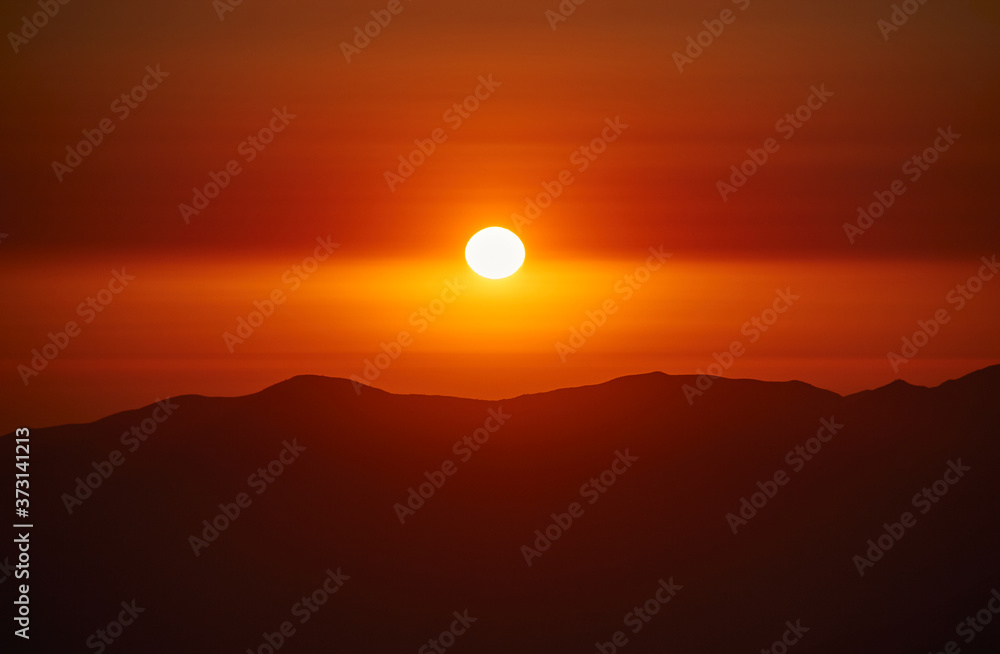 Fototapeta premium Increíble puesta de sol en un atardecer entre montañas