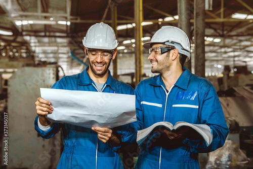 Happy Work. Factory Engineer with white safety helmet smile and relax talk during work on production in a factory. Industrial,Warehouse Heavy Mechanic, Engineering Concept.