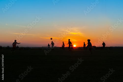 Young males practicing and training at soccer at twilight