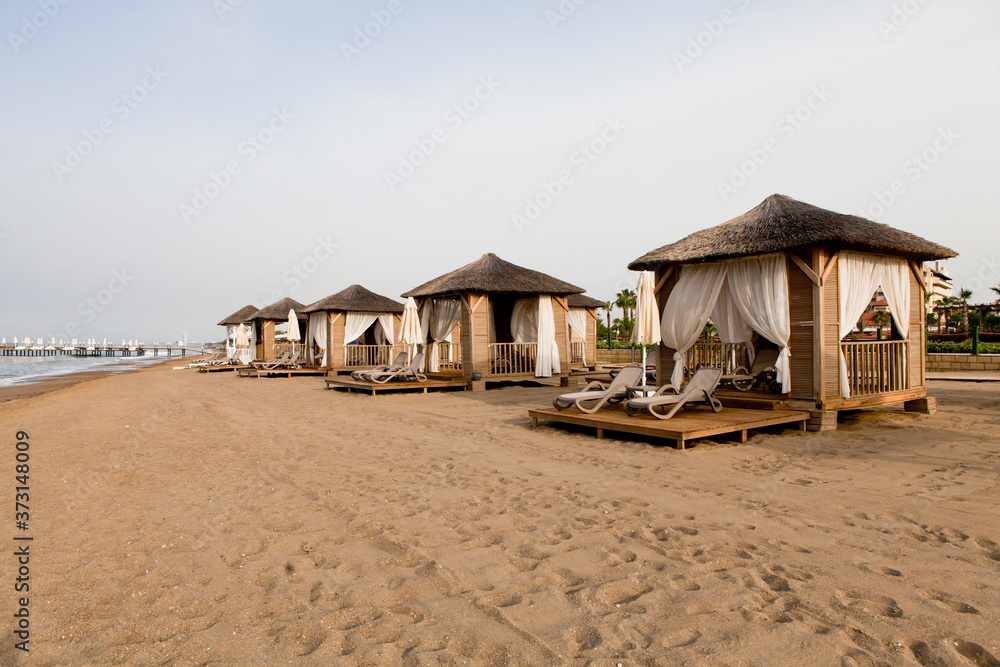 Beach near the sea with sun loungers and parasols