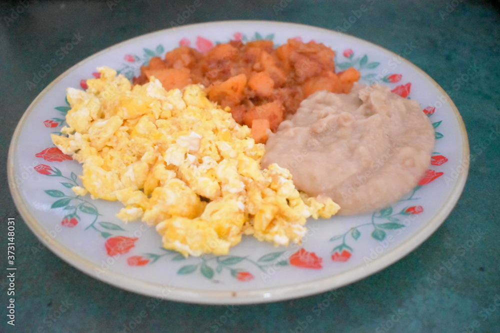 Un rico desayuno de papas con chorizo, huevos revueltos y frijoles Un rico desayuno de papas con chorizo, huevos revueltos y frijoles