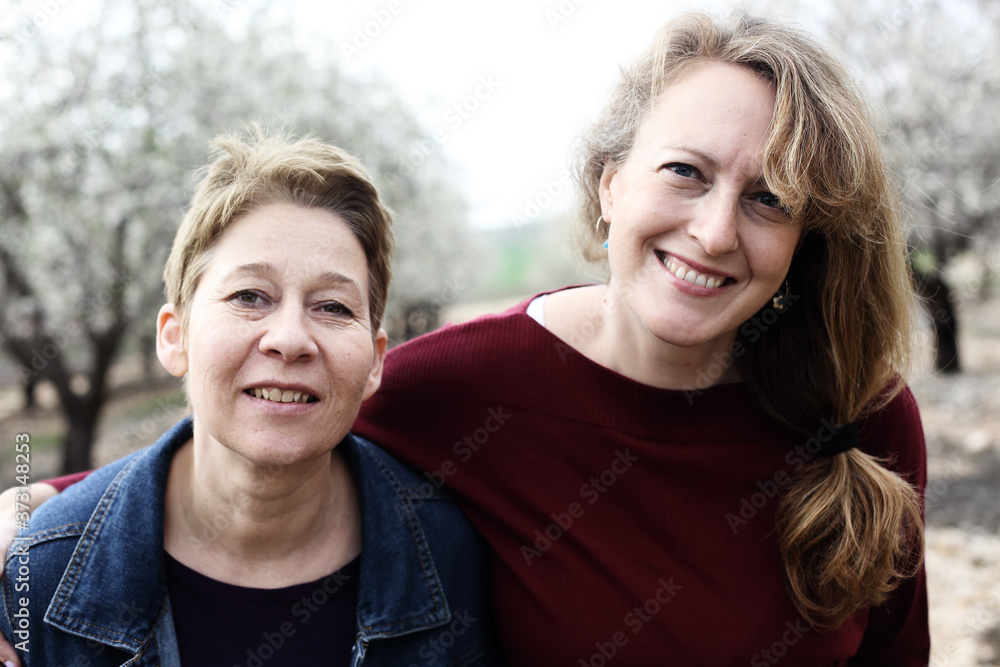 Obraz premium Portret dwóch uśmiechniętych prawdziwych dojrzałych kobiet na zewnątrz