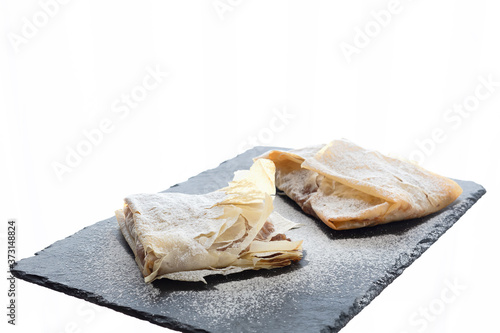 Small desserts of phyllo dough filled with dried fruit. White background and copy space.