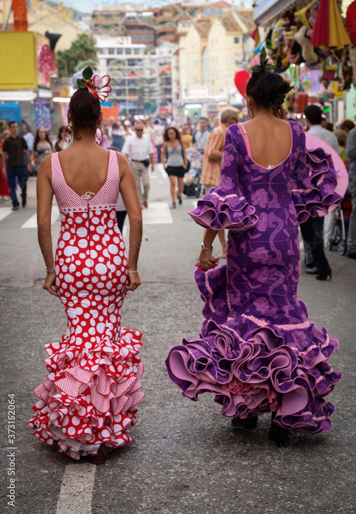 Naklejka premium Dos jovenes vestidas con traje de flamenca paseando por el recinto de la Feria de Fuengirola