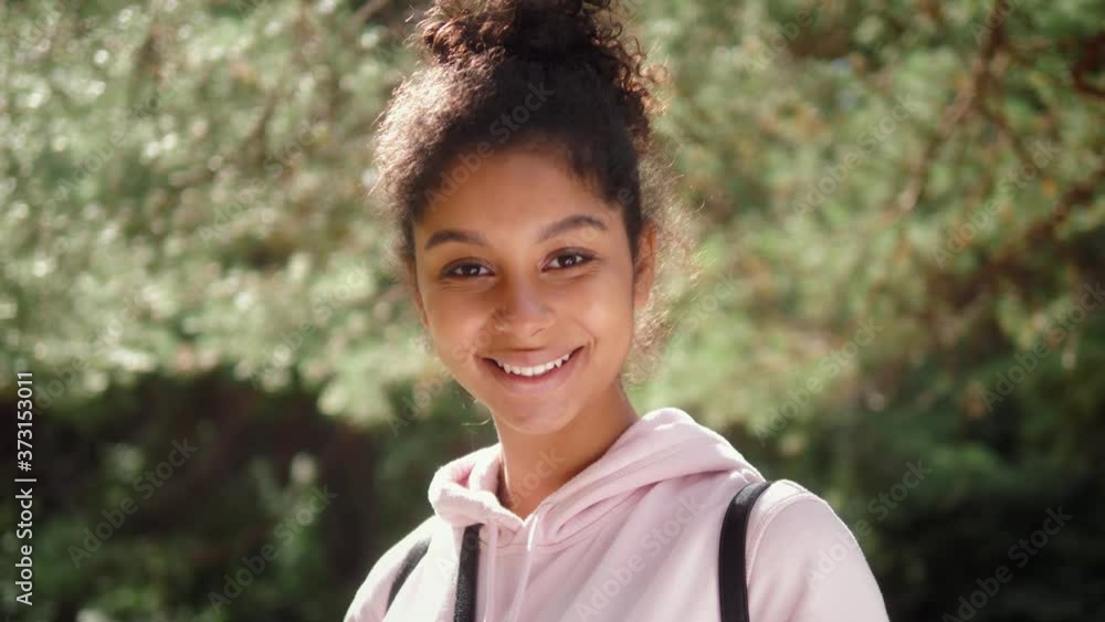 Portrait of a happy black african american woman smiling, tourist student, black fashion model smiling, curly afro hairstyle, generation z lifestyle, teenager walking Portrait of a happy black african american woman smiling, tourist student, black fashion model smiling, curly afro hairstyle, generation z lifestyle, teenager walking