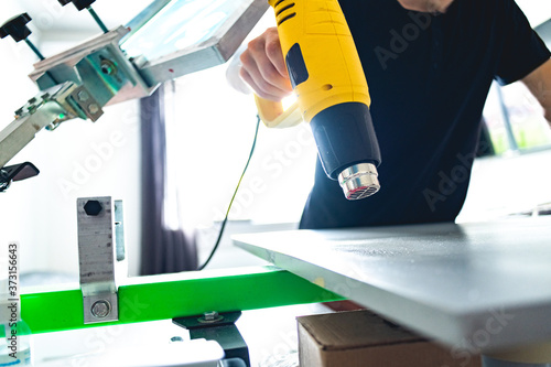Wallpaper Mural Cropped view of craft worker drying surface of screen printing press with heat gun in designer studio  Torontodigital.ca