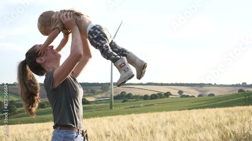 Happy mother and son, son is laughing as mother throws him in the air in beautiful countryside