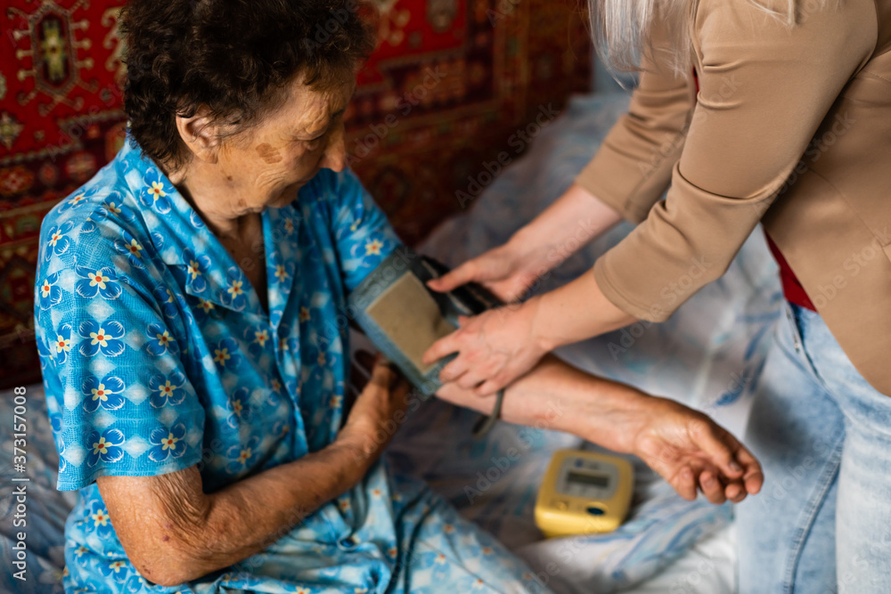 Elder woman having measured blood pressure by cardiologist