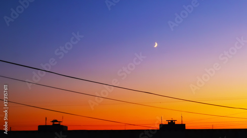 Beautiful bright sunset over the roofs of houses copy space