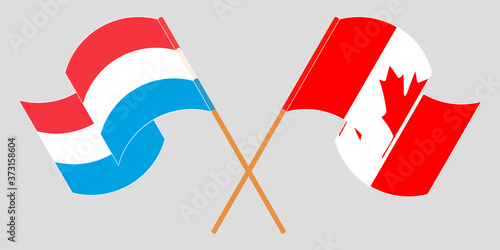 Crossed and waving flags of Luxembourg and Canada