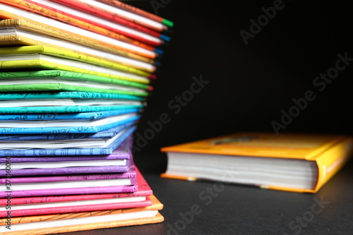 Business magazines - stack of books with colorful covers arrange in color of rainbow on black background