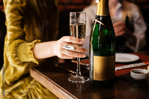 Girl holding a glass of champagne in her hand. © Евгений Гвоздев
