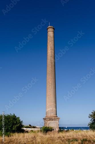 Chimney of an old factory facing the sea