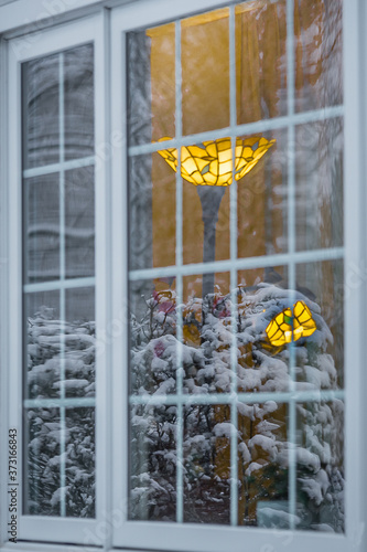 window of a warm house with freezing snow reflection © Jay