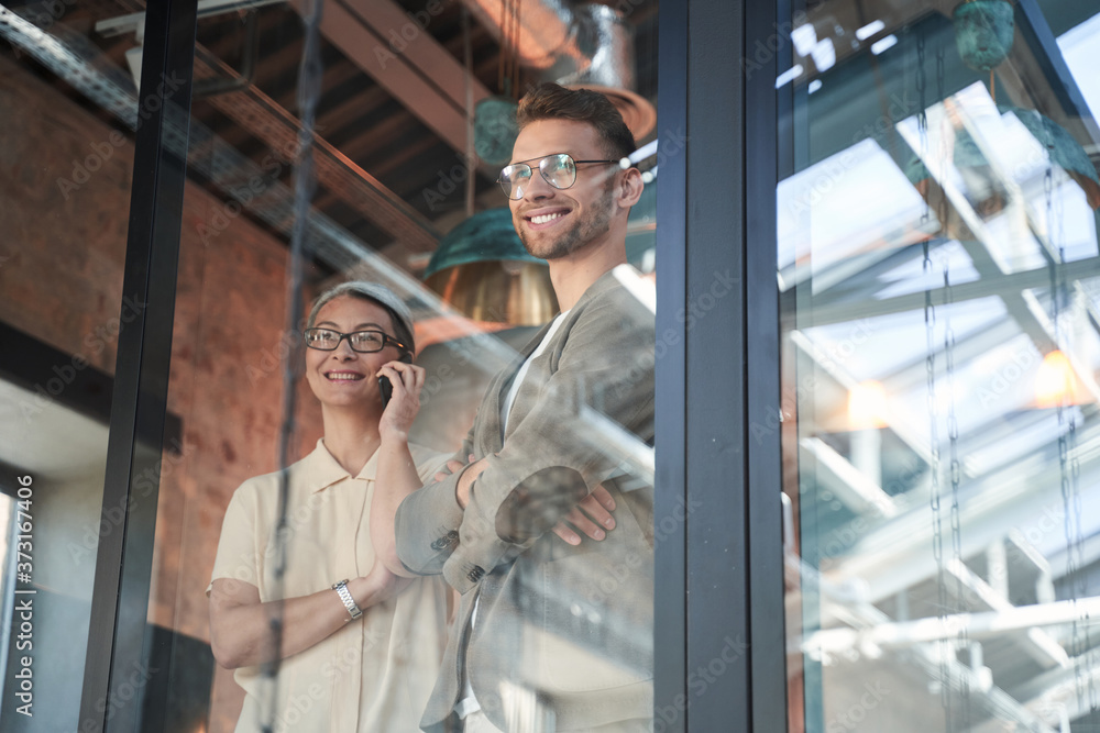 Adult woman talking on mobile near the man in glasses Adult woman talking on mobile near the man in glasses