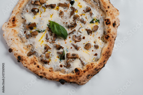 Italian pizza with mushrooms, cheese and olive oil on a white background.