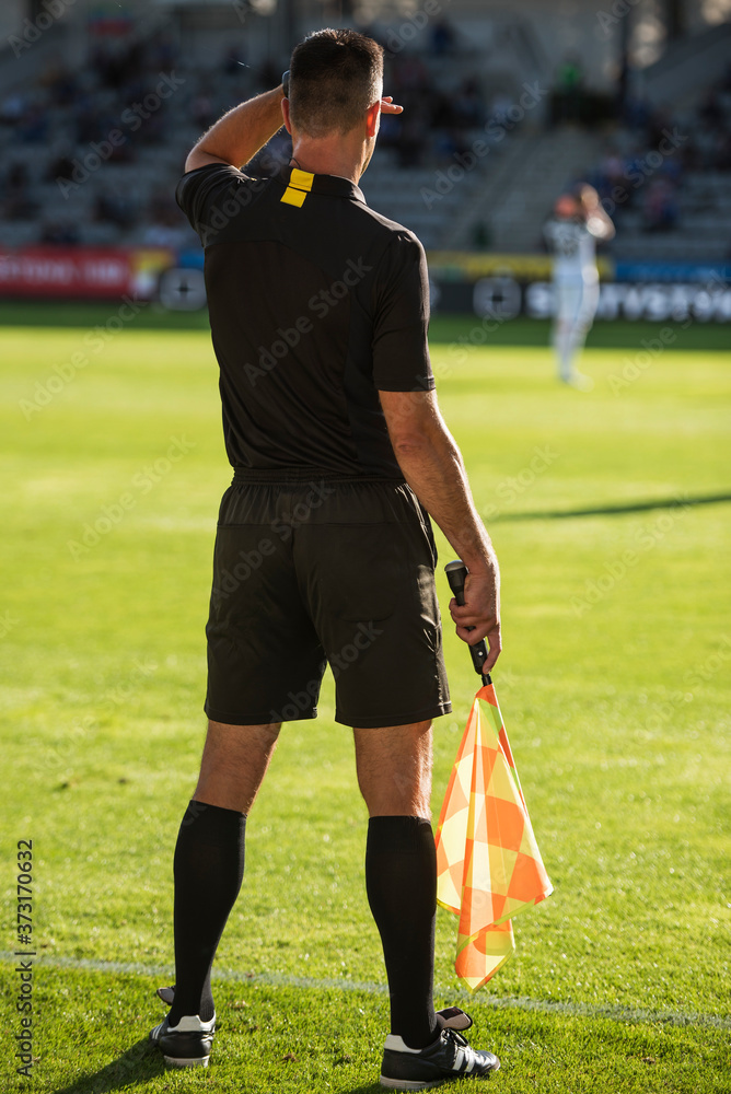 Obraz premium Touchline referee looking against the light during the soccer match.