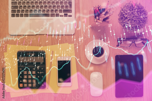 Double exposure of forex chart hologram over desktop with phone. Top view. Mobile trade platform concept.