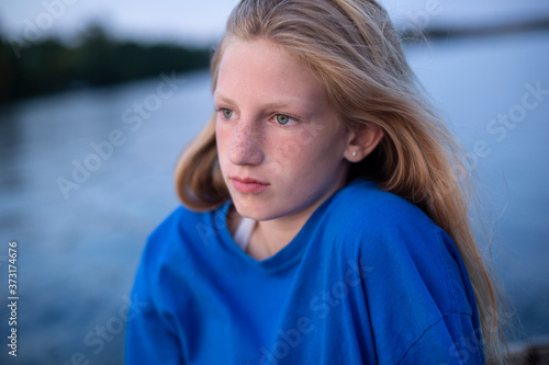 Blue Shirt Worn by Blonde Girl on a lake outdoors