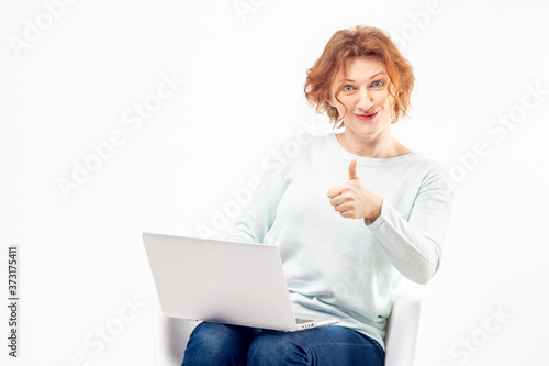 Wallpaper Mural Portrait of a red haired mature woman with content or satisfied expression on her face with a laptop and thump up against white background Torontodigital.ca