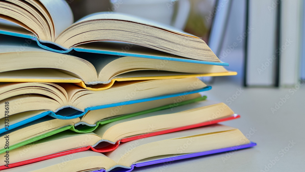 Close up, Desk with stack of open study books. Textbooks for the student, university. Study from home. Distance education concept. Close up, Desk with stack of open study books. Textbooks for the student, university. Study from home. Distance education concept.