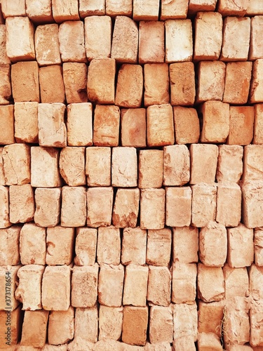 A stack of red bricks fills the frame used to for construction in India